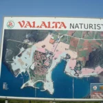 Welcome sign and map at Valalta Nude Beach