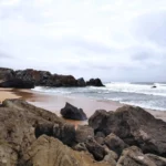 Rock formations line the beach at Praia do Abano